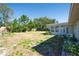 Green backyard featuring lush grass, mature trees, and an outdoor patio at 2681 Renatta Dr, Belleair Bluffs, FL 33770