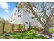 Landscaped side yard featuring a modern home with white exterior, wood accents and a privacy fence at 307 15Th N St, St Petersburg, FL 33705