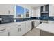 Bright kitchen features white cabinetry, stainless steel appliances, and a farmhouse sink at 307 15Th N St, St Petersburg, FL 33705