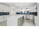 Kitchen features white cabinets, stainless steel appliances, a center island, and stylish blue backsplash at 307 15Th N St, St Petersburg, FL 33705