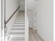 Bright entryway featuring a modern staircase with white risers, wood railing, and light wood floors at 307 15Th N St, St Petersburg, FL 33705