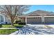 Charming home featuring a two-car garage, landscaped yard, and mature tree providing shade and curb appeal at 31826 Larkenheath Dr, Wesley Chapel, FL 33543