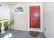 Inviting front entrance featuring a red door, decorative window, and well-maintained porch area, creating a warm welcome at 31826 Larkenheath Dr, Wesley Chapel, FL 33543