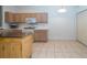 Well-lit kitchen with wood cabinets, modern appliances, tile flooring and a pantry for ample storage space at 31826 Larkenheath Dr, Wesley Chapel, FL 33543