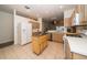 Functional kitchen featuring wood cabinets, tile flooring, a movable kitchen island and modern appliances at 31826 Larkenheath Dr, Wesley Chapel, FL 33543