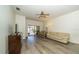 Comfortable living room featuring wood flooring, ceiling fan, sliding doors to the patio, and neutral decor at 31826 Larkenheath Dr, Wesley Chapel, FL 33543