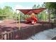 Community playground with slide and climbing equipment shaded by a canopy at 31826 Larkenheath Dr, Wesley Chapel, FL 33543