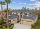 Aerial view of a two-story home with a black roof, two car garage, and lush tropical landscaping at 3339 Diamond Falls Cir, Land O Lakes, FL 34638