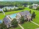 Aerial view of the community clubhouse, pool, and lake surrounded by lush greenery at 3339 Diamond Falls Cir, Land O Lakes, FL 34638