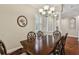 Formal dining room with dark wood table, stylish chandelier, and a view towards the home's front entry at 3339 Diamond Falls Cir, Land O Lakes, FL 34638