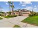 Tan two-story home with black roof, three-car garage, and manicured landscaping at 3339 Diamond Falls Cir, Land O Lakes, FL 34638