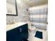 Charming bathroom with patterned accent wall, a well-lit mirror and a shower featuring a neutral curtain at 3367 Crystal E Ct # F, Palm Harbor, FL 34685