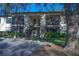 Two-story condo building featuring upper units with screened-in patios and well-maintained landscaping at 3367 Crystal E Ct # F, Palm Harbor, FL 34685