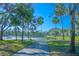 Walking path with a view of a serene lake surrounded by lush greenery and mature trees at 3367 Crystal E Ct # F, Palm Harbor, FL 34685