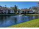 Scenic view of a community pond with a fountain, surrounded by lush landscaping and residential buildings at 3367 Crystal E Ct # F, Palm Harbor, FL 34685