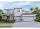 Two story home featuring a gray exterior, a two car garage, a manicured lawn, and tasteful landscaping at 3422 Hazel Hollow Way, Plant City, FL 33565
