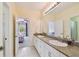 Bathroom with double sinks and granite countertops, leading to other rooms at 3900 W Platt St, Tampa, FL 33609
