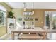 Well lit Dining room with a white table and benches, cabinet storage, and hanging lights at 3900 W Platt St, Tampa, FL 33609