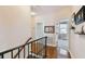 Upstairs hallway featuring hardwood floors and a view into a bedroom at 3900 W Platt St, Tampa, FL 33609