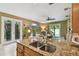 Kitchen view showcasing granite countertop, stainless sink, and an open view to the living area and backyard at 3900 W Platt St, Tampa, FL 33609