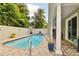 Inviting pool area featuring brick pavers, lush landscaping, and a covered patio for outdoor relaxation at 3900 W Platt St, Tampa, FL 33609