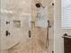 This luxurious shower features a bench, beautiful tile, rainfall showerhead, and a convenient hand-held sprayer at 3900 W Platt St, Tampa, FL 33609