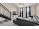 Bright living room boasts a modern black leather sofa, staircase, and natural light from large windows at 4221 W Spruce St # 1407, Tampa, FL 33607