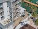 Aerial view of building with waterfront patio, docks and palm trees at 445 Hamden Dr # 201, Clearwater Beach, FL 33767