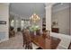 Open-concept dining room with a wooden table, chairs, chandelier, and views to the living room at 4677 Aylesford Dr, Palm Harbor, FL 34685