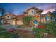 Beige stucco home with red tile roof, blue front door, circular design element, landscaped front yard and two-car garage at 4677 Aylesford Dr, Palm Harbor, FL 34685