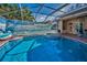 Backyard pool and lanai area with screened enclosure and lush tropical landscaping at 4677 Aylesford Dr, Palm Harbor, FL 34685