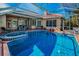 Inviting pool area with a spa, covered lanai, and comfortable seating for outdoor relaxation at 4677 Aylesford Dr, Palm Harbor, FL 34685
