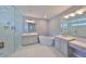 This spacious bathroom features a soaking tub, double vanity, and walk-in shower with white marble tiling at 47 Adalia Ave, Tampa, FL 33606
