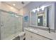 Bathroom featuring a marble tiled walk-in shower, toilet, vanity and large mirror with decorative lighting at 47 Adalia Ave, Tampa, FL 33606