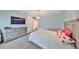 Bedroom with blue walls features a dresser with a TV, large bed, and a view into the hallway at 47 Adalia Ave, Tampa, FL 33606