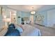 Bright bedroom featuring a decorative chandelier, a dresser with a mirror, and a queen-sized bed at 47 Adalia Ave, Tampa, FL 33606