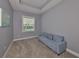 Bright bedroom with a large window, plush carpet, and a comfortable couch with blue pillows at 47 Adalia Ave, Tampa, FL 33606