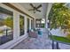 Cozy outdoor patio with wicker seating, ceiling fan, and views of the lush backyard and pool area at 47 Adalia Ave, Tampa, FL 33606