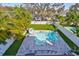 Aerial view of the fenced in backyard featuring a modern pool, patio, and lush landscaping at 47 Adalia Ave, Tampa, FL 33606
