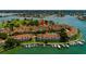 Aerial view of waterfront condo community featuring boat docks, lush landscaping, and serene water views at 530 Sandy Hook Rd, Treasure Island, FL 33706