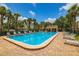 Bright community pool with a brick deck, lounge chairs, cabana, and lush landscaping, perfect for relaxation at 530 Sandy Hook Rd, Treasure Island, FL 33706