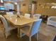 Dining room with a light wood table, white upholstered chairs, and beach-themed accents at 530 Sandy Hook Rd, Treasure Island, FL 33706