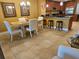 Inviting dining area featuring tile floors, a dining table with white chairs, and a kitchen bar at 530 Sandy Hook Rd, Treasure Island, FL 33706