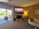 Living room with fireplace and access to the balcony, offering views of lush landscaping and the bay at 530 Sandy Hook Rd, Treasure Island, FL 33706