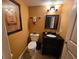 Beautifully appointed powder room with elegant fixtures, dark vanity and textured walls at 530 Sandy Hook Rd, Treasure Island, FL 33706