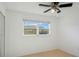 Bright bedroom with ceiling fan, tile floor, and a sunlit window view at 5967 Terrace Park N Dr # 202, St Petersburg, FL 33709
