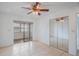 Open bedroom layout with a sunroom, mirrored closet, tile floors, and ceiling fan at 5967 Terrace Park N Dr # 202, St Petersburg, FL 33709
