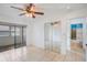 Bright bedroom featuring tile floors, mirrored closet doors, and a ceiling fan with light fixture at 5967 Terrace Park N Dr # 202, St Petersburg, FL 33709