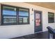 A close-up of a condo's exterior, featuring the entrance door, windows, and a friendly welcome mat at 5967 Terrace Park N Dr # 202, St Petersburg, FL 33709
