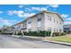 Inviting exterior of a multi-Gathering unit showcasing lush green landscaping against a partly cloudy sky at 5967 Terrace Park N Dr # 202, St Petersburg, FL 33709